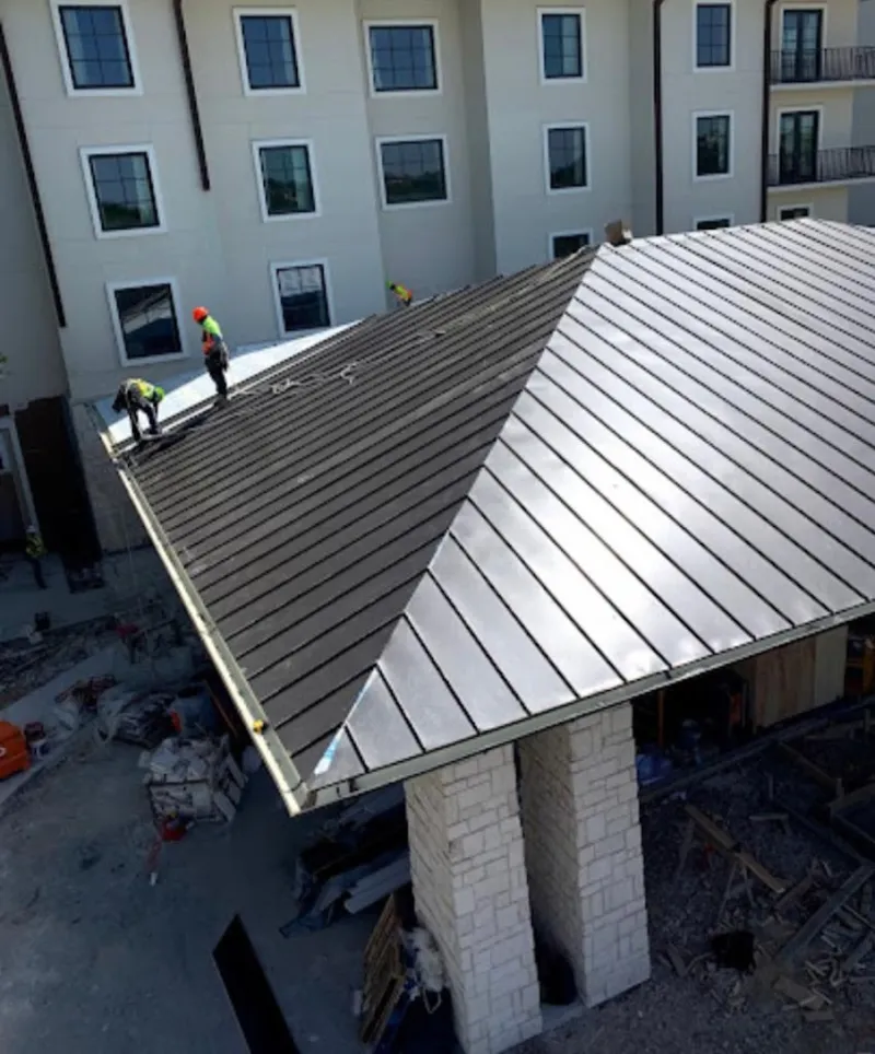 Crew installing standing seam metal roof panels on a commercial project in Sangaree